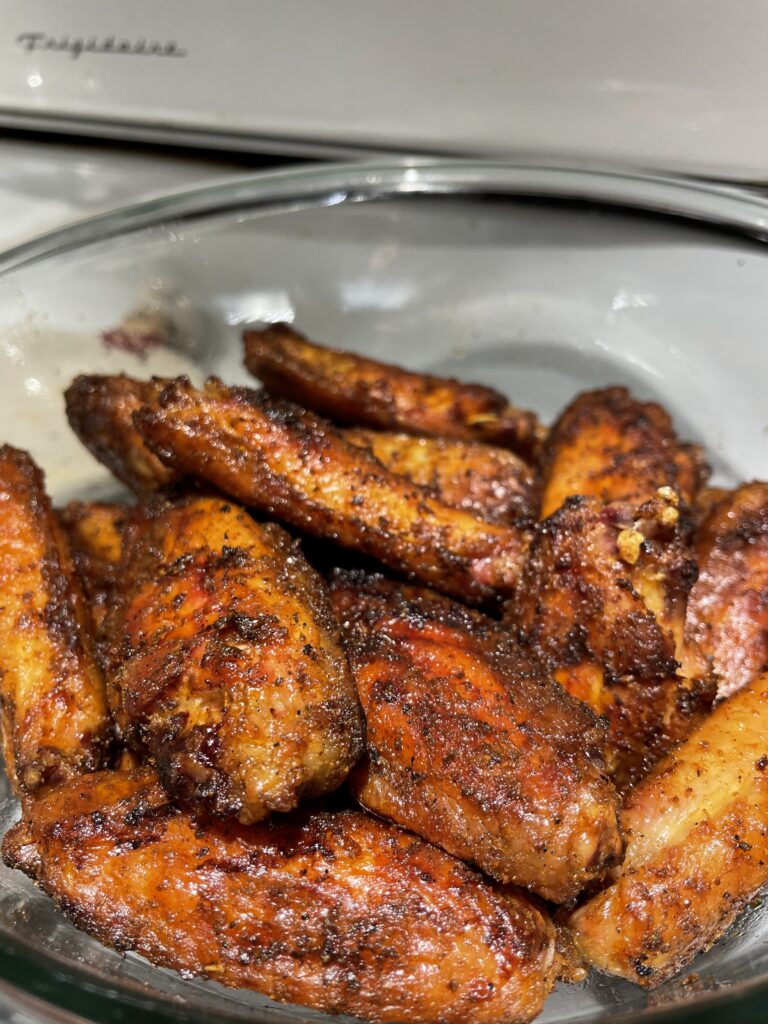 Wings in a bowl after oil and rub, but raw before being 