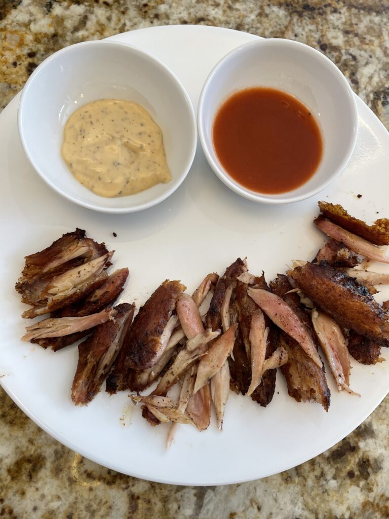 Chicken wings off the bone with dipping sauces positioned in the shape of a smile.