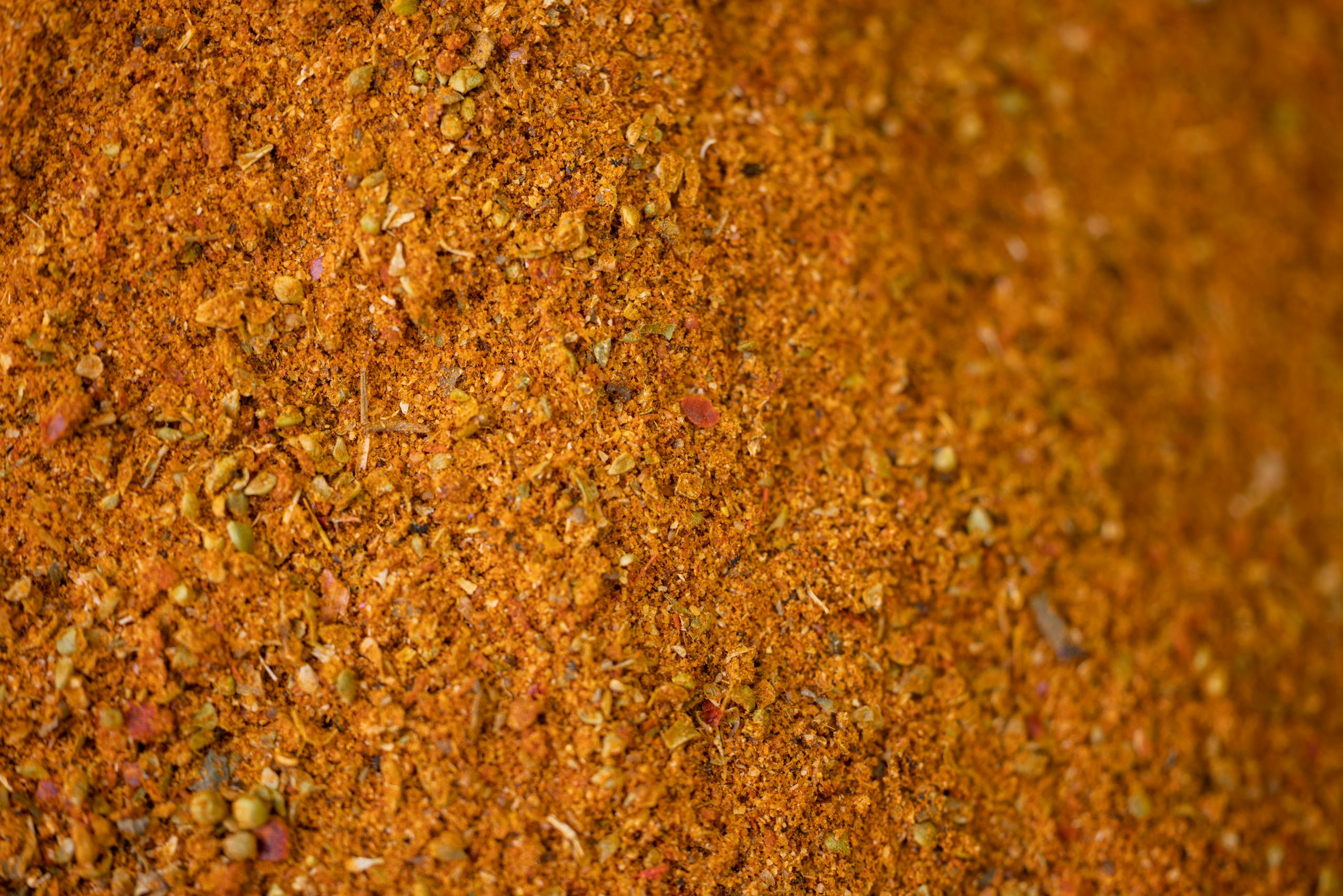 High-resolution close-up of a brown spice and herb blend, perfect for cooking and seasoning.